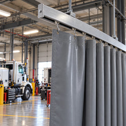 Shop curtain partially open on overhead track in a fleet maintenance garage